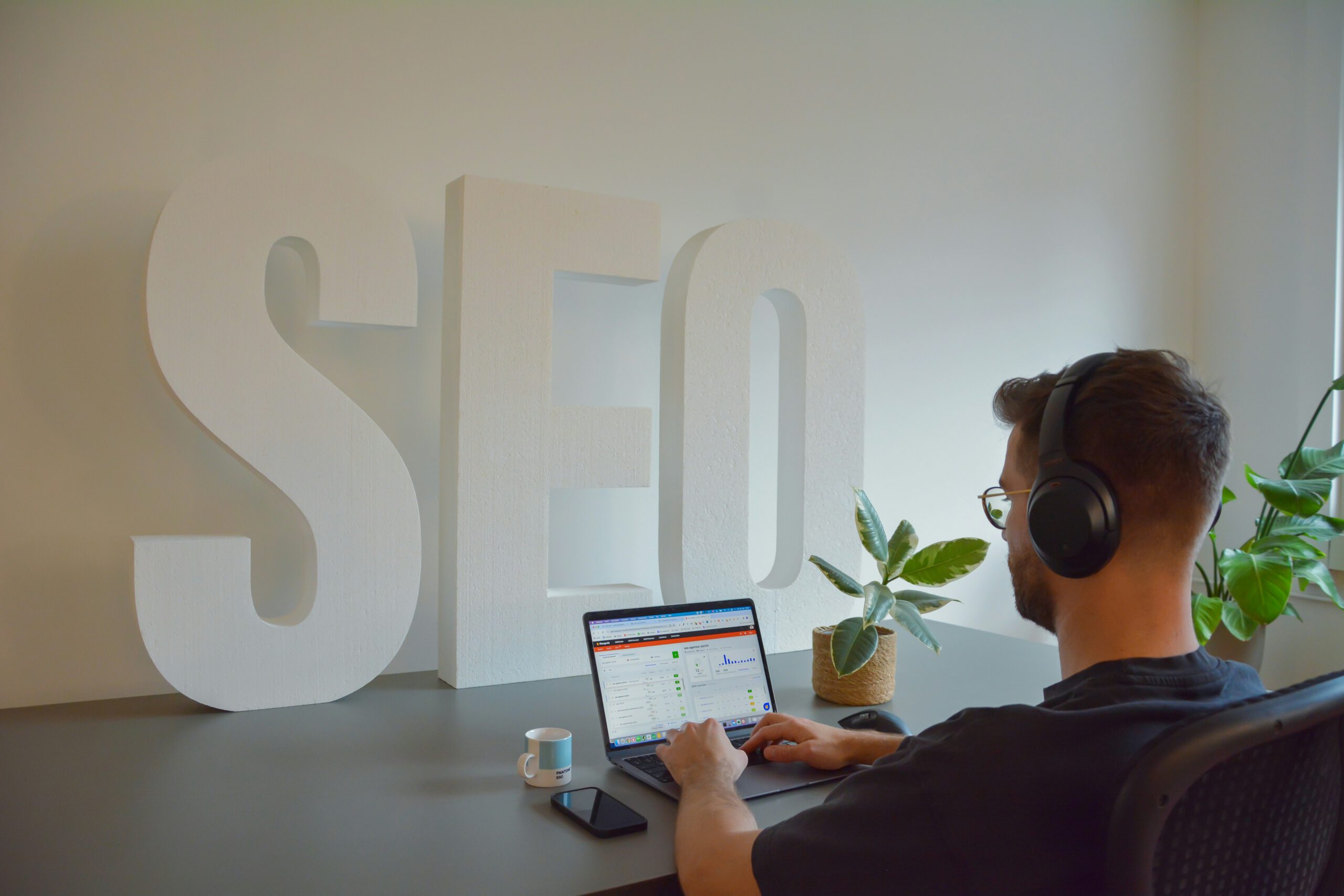 Wat is GEO uitgelegd vanuit een SEO werkplek met laptop, analytics en focus op online vindbaarheid